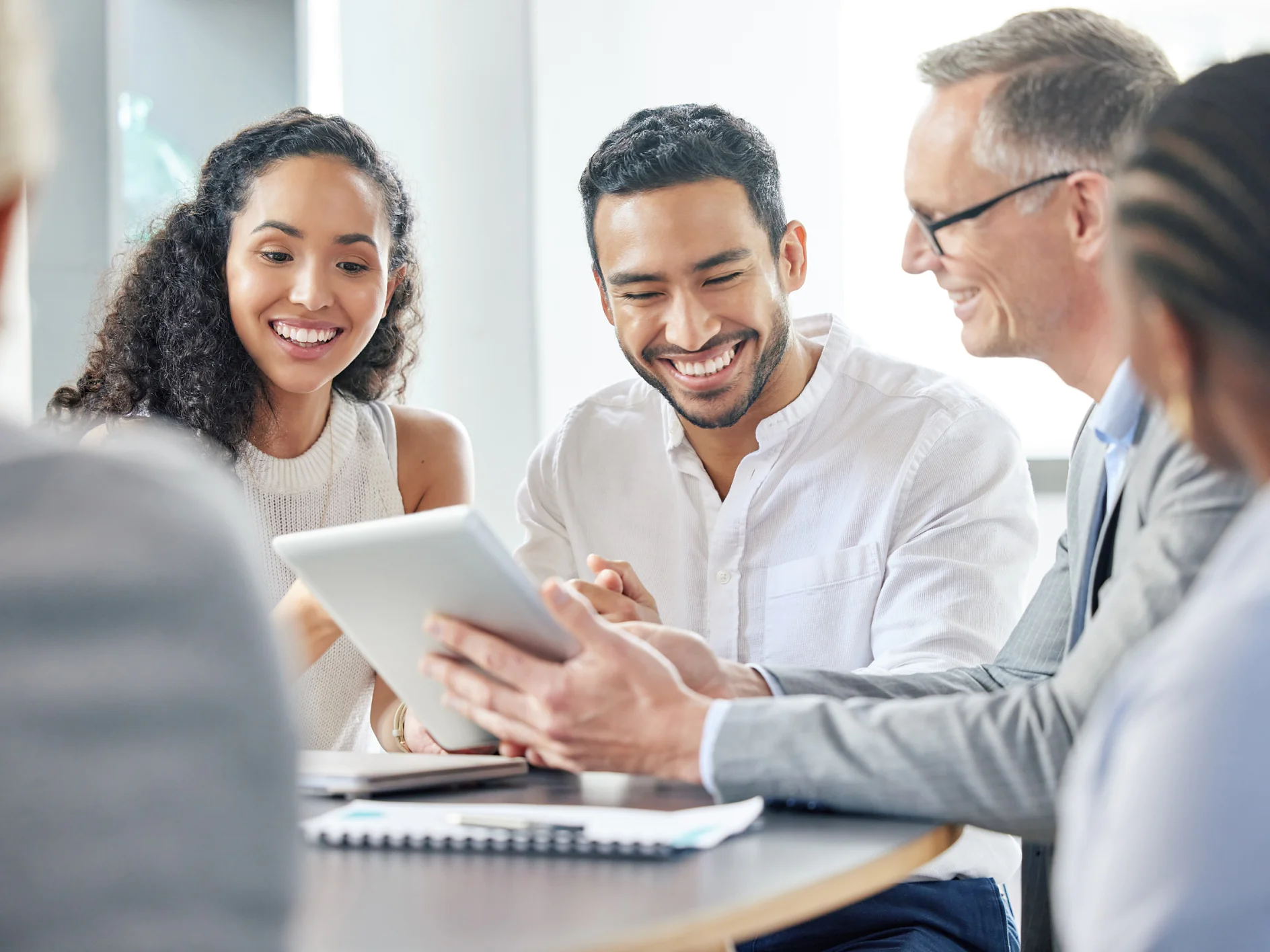 Happy, business people and meeting with tablet in office for communication of company strategy and goals. Smile, corporate group and discussion with technology in boardroom for training interns.